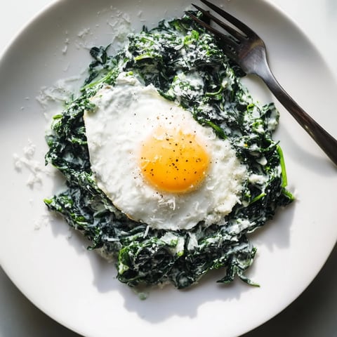 Cremiger Spinat mit knusprigem Ei, perfekt für ein herzhaftes Frühstück.  